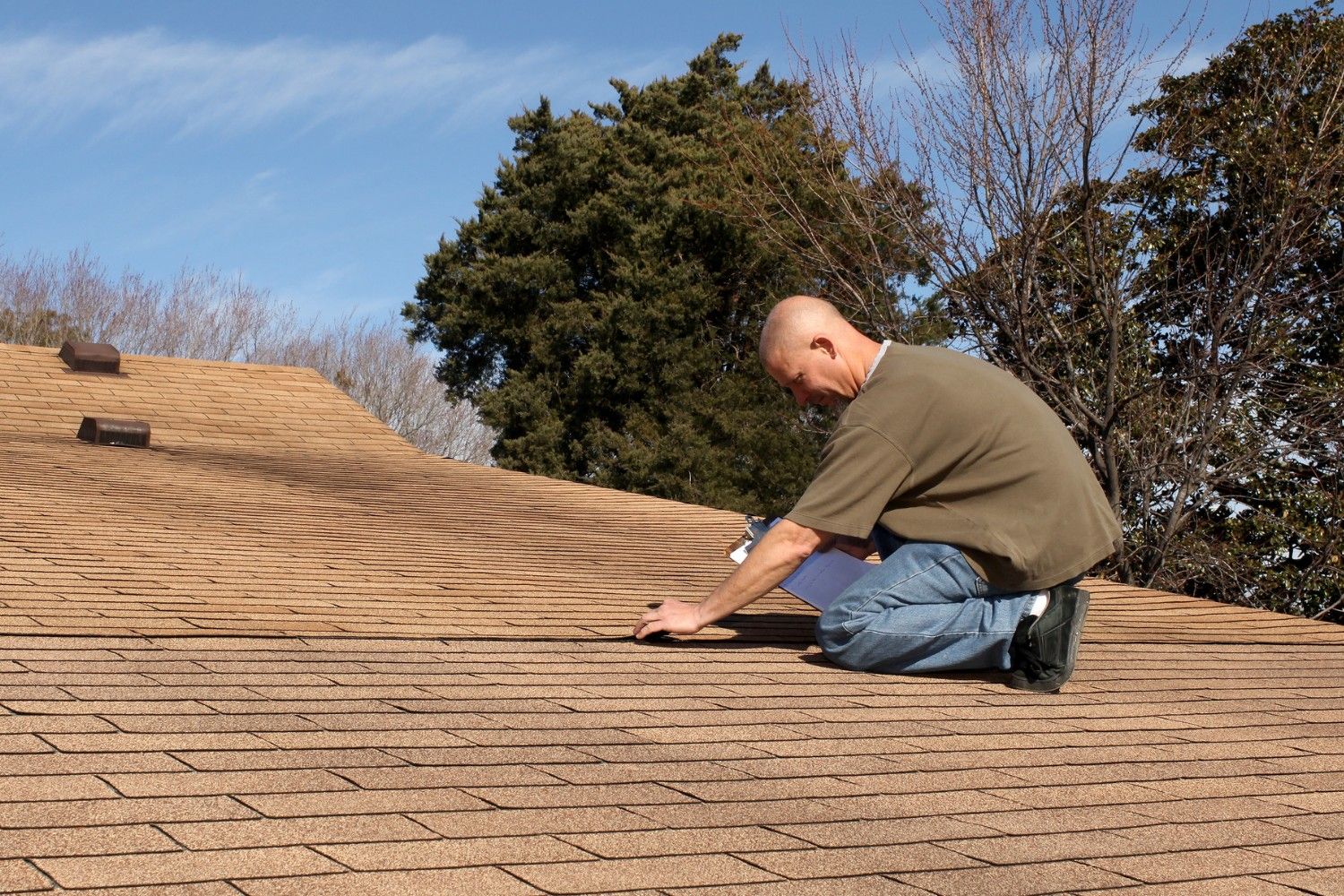 man on roof performing roof maintenance